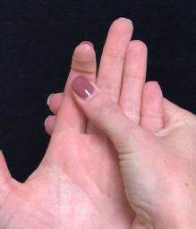Palm up, the other hand supports the finger just below the end joint while it bends and straightens.